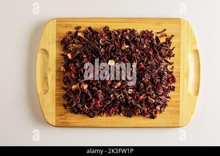 Tea made from dried pomegranate flowers. Increases immunity. Background of fragrant tea on a wooden board. Stock Photo