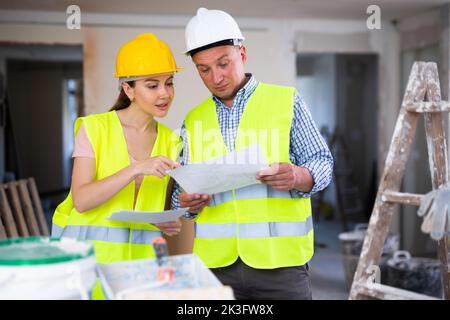 Man and woman builders talking in house Stock Photo