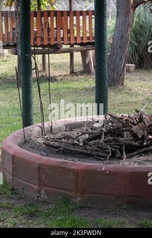Rustic outdoor fire pit with stacked wood in backyard garden Stock Photo