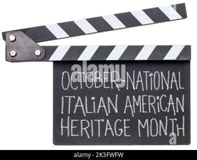 October - National Italian American Heritage Month, white chalk handwriting ion a clapboard isolated on white, reminder of cultural event Stock Photo