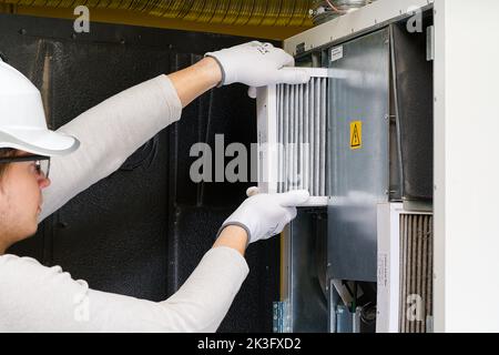hvac filter replacement home central air system. servicemen changing filter in furnace. Stock Photo