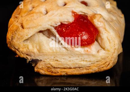 Bun with red strawberry jam baking in electric oven: close up Stock Photo