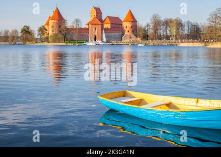 Trakai castle with boat floating on water in foreground, Lithuania Stock Photo