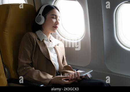 Asian Business woman sleeping in the airplane while flight go to meet client Stock Photo