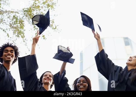 We made it. A group of smiling college graduates celebrating their graduation. Stock Photo