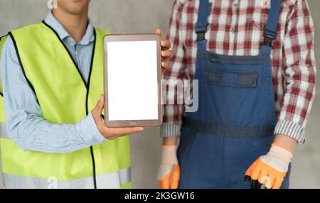 Tablet computer with a blank screen in the hands of an engineer and builder. construction site, business and people concept Stock Photo