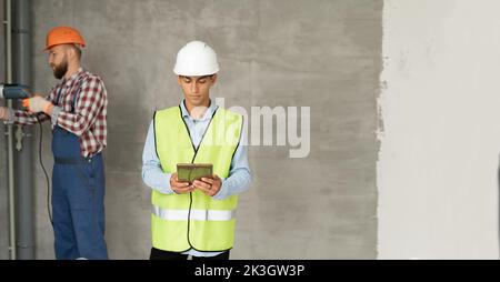 business builder people at construction site working using digital tablet. Builder, inspector, engineer, architect, customer, people working at buildi Stock Photo