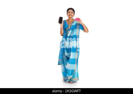 Portrait of a Bengali woman holding credit card and mobile phone against white background Stock Photo