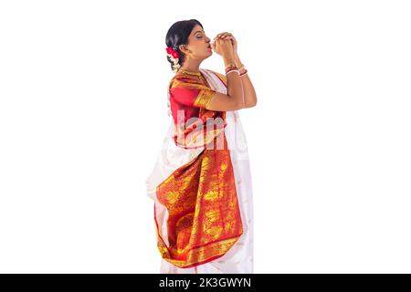 Bengali woman in white sari playing sankh Stock Photo