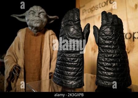 Previously unissued photo dated 08/09/22 of Dave Prowse’s screen-matched Darth Vader gloves from the 1977 film ‘Star Wars: A New Hope’ (estimate £150k-250k) are seen alongside Yoda’s Jedi Robes from the 1999 film ‘Stars Wars: The Phantom Menace’ (estimate £40,000-60,000) during a preview at the Propstore in Rickmansworth, Hertfordshire for the upcoming Propstore Entertainment Memorabilia Live Auction which will be held over 4 days from 3rd to 6th November. Issue date: Tuesday September 27, 2022. Stock Photo
