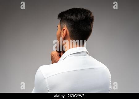 Studuo shot of thinking businessman standing over gray background Stock Photo