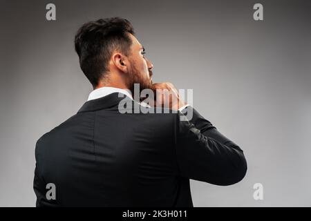 Studuo shot of thinking businessman standing over gray background Stock Photo