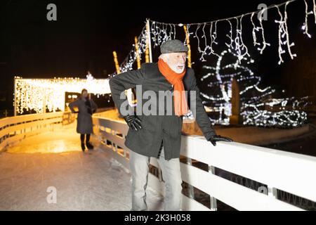 Older man skating on ice and having fun during Christmas and winter time Stock Photo