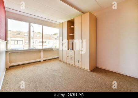 cupboard placed near doors with red and white walls Stock Photo