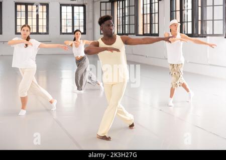 Portrait of smiling young dancing people practicing vigorous swing in studio Stock Photo