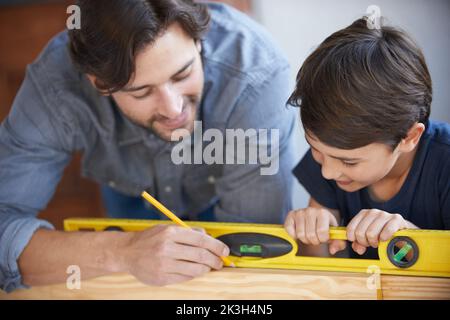 Teaching his son about the carpentry trade. A father and son doing woodwork together. Stock Photo