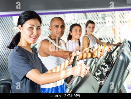 People having running elliptical trainer class in club Stock Photo