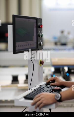 Operator controls computerized industrial machine. Selective focus. Stock Photo