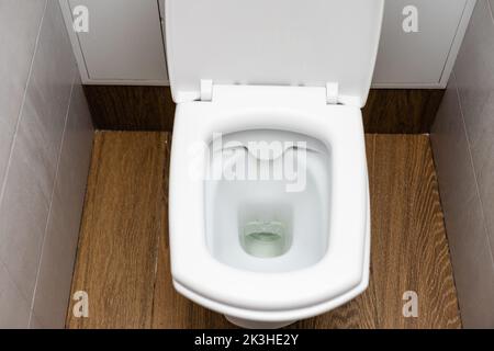 Toilet - Lavatory pan with the push button and toilet brush Stock Photo