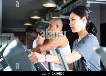 People having running elliptical trainer class in club Stock Photo