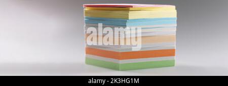 Uneven stack of sticky post it notes on grey surface, bunch of clean papers Stock Photo
