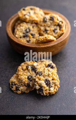 Wholegrain oat cookies. Cookies with oatmeal and raisins on the dark table. Stock Photo