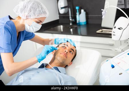 Man receiving carboxytherapy procedure at beauty clinic Stock Photo