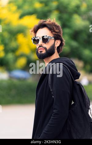 man with fashionable sunglasses walking outdoors Stock Photo