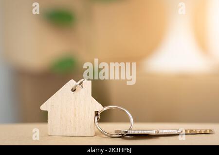 House keys on keyring in the shape of a wooden house with copy-space for text Stock Photo