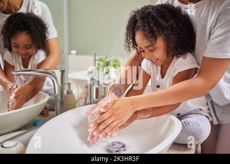 Child, washing hands and family rinsing, cleaning and good hygiene against bacteria or germs for infection or virus protection in bathroom. Girl kid Stock Photo