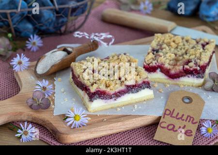 pieces of plum poppy seed cheesecake with cinnamon crumble on wooden board Stock Photo