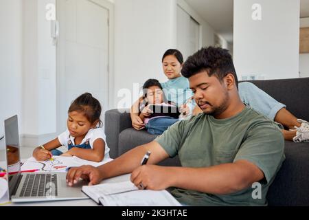 Family, children and education with a father working from home and his daughter doing homework for school. Learning, remote work and studying with a Stock Photo