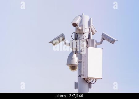 Public security cameras, capture the townspeople. White cameras are mounted on a metal pole Stock Photo