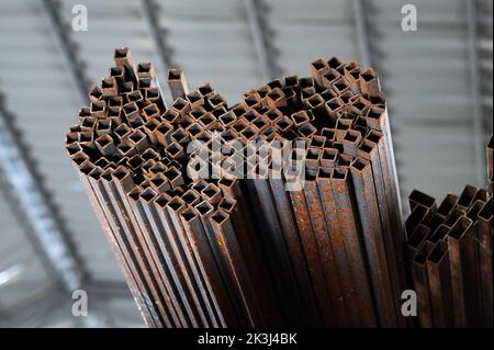 Square tubing pile on rack unit in cold factory warehouse Stock Photo ...