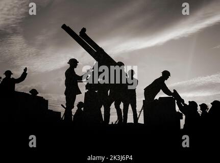 Soldiers silhouetted against the sky prepare to fire an anti-aircraft gun. On the right of the photograph a soldier is being handed a large shell for the gun. The Battle of Broodseinde was part of the 1917 third Battle of Ypres – engineered by Sir Douglas Haig to capture the Passchendaele ridge. Stock Photo