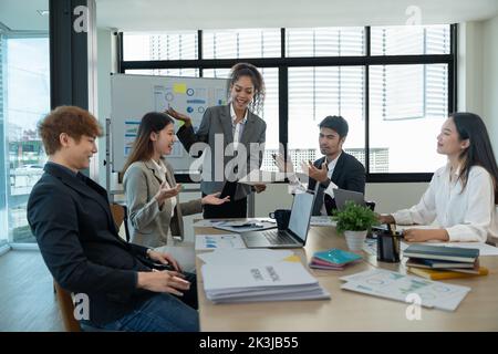 diverse business team people discuss financial result review paperwork share ideas brainstorm collaborate work in teamwork at group briefing table. Stock Photo