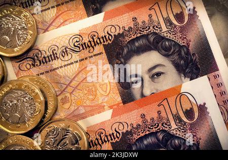 Close-up of Queen Elizabeth II face portrait on Ten Pound Bank of England banknotes plus coins. Plastic polymer currency introduced 2017. Stock Photo