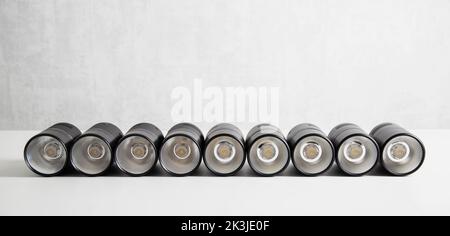 Spot overhead black lamps on a stretch ceiling on a white background. Lamps in the shape of a tube Stock Photo