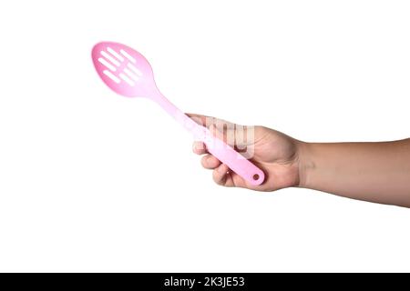 Pink silicone kitchen spatula skimmer in hand on white background, isolate. Close-up, cooking food Stock Photo