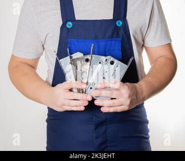 Door fitter holding door hardware, magnetic door latch Stock Photo