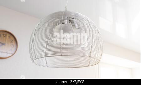 Modern chandelier in the kitchen with three LED lights and a metal frame. White hanging chandelier, home Stock Photo