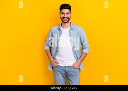 Photo of young positive guy confidently looking camera sure best worker hands pockets isolated on yellow color background Stock Photo