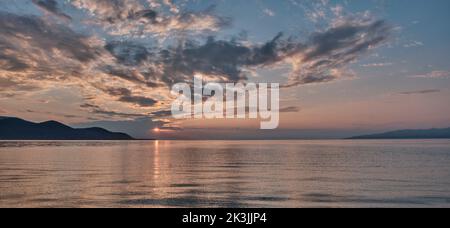 Colorful summer sunset on lake. Scenic dramatic clouds on sky. Stock Photo