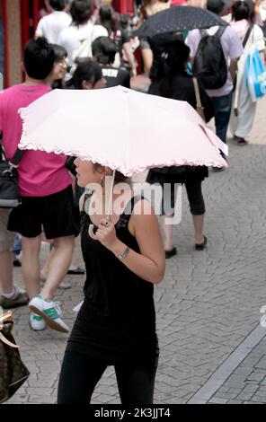 TOKYO,JAPAN-JULY 05: Unidentified Woman with pink Umbrella shopping at  Harajuku Street. July 05,2008 in Tokyo, Japan Stock Photo