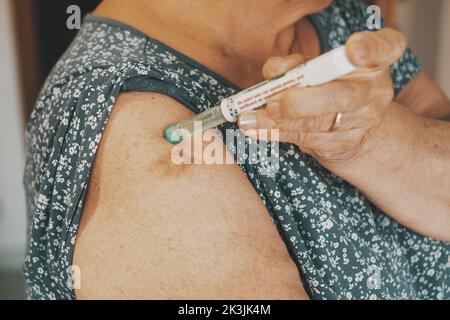 Close up of woman arm with insulin pen. Mature lady injecting diabetes treatment with syringe. Concept of diabetic people taking care. Health and age Stock Photo