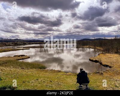 A male photographer taking pictures of the nature in Thingvellir National Park, Iceland Stock Photo