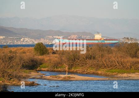 Container ship MAERSK KOTKA, near Malaga, with Guadalhorce natural park in front, Andalucia, Spain. Stock Photo