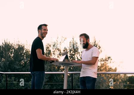 Two young entrepreneur men having a business talk while working online with their tablets Stock Photo