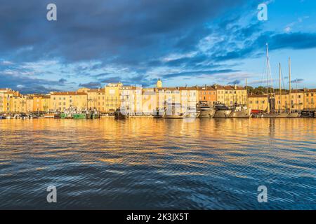 Scenic view of Saint-Tropez in a golden warm sunset light against dramatic blue sky with clouds Stock Photo