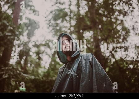 Man wearing a raincoat in a rainforest Stock Photo